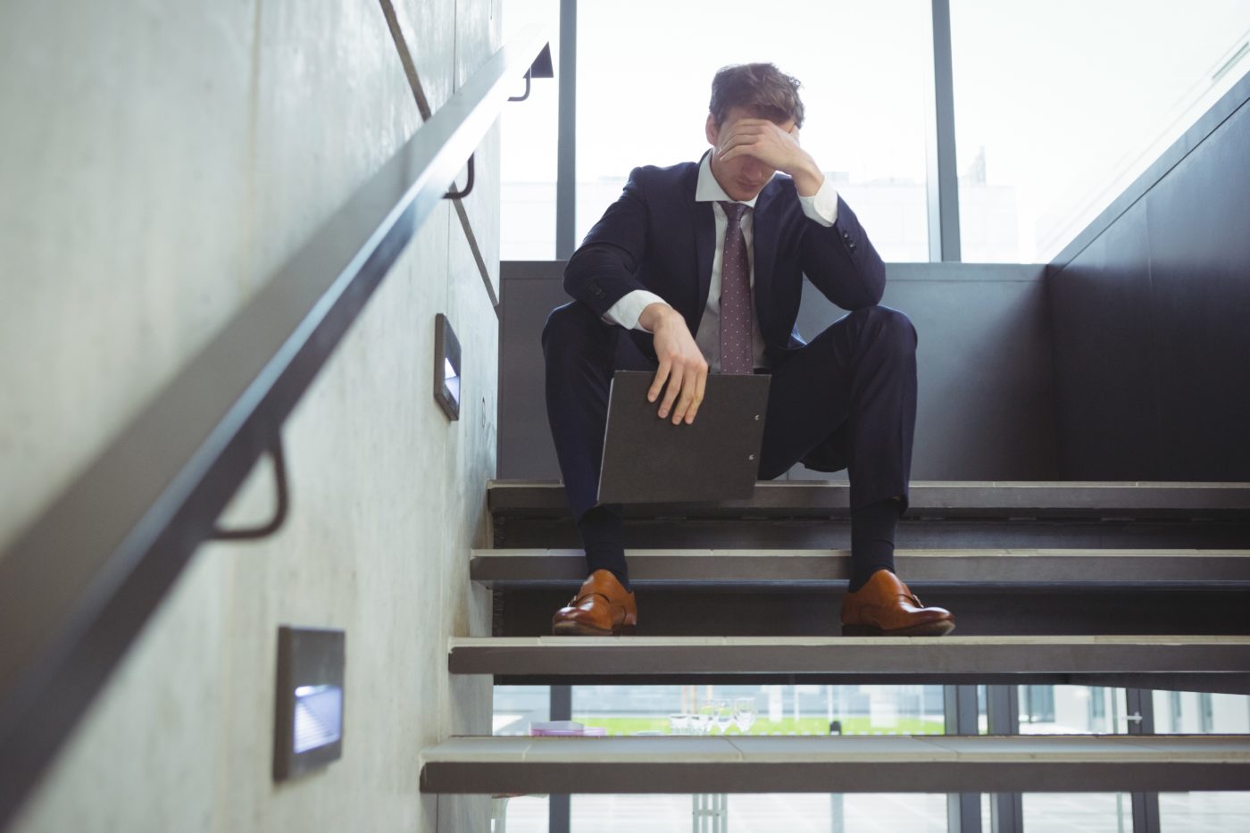 przedsiębiorca, siedzący na schodach zastanawia się o jakich obowiązkach prawnych zapominają przedsiębiorcy?